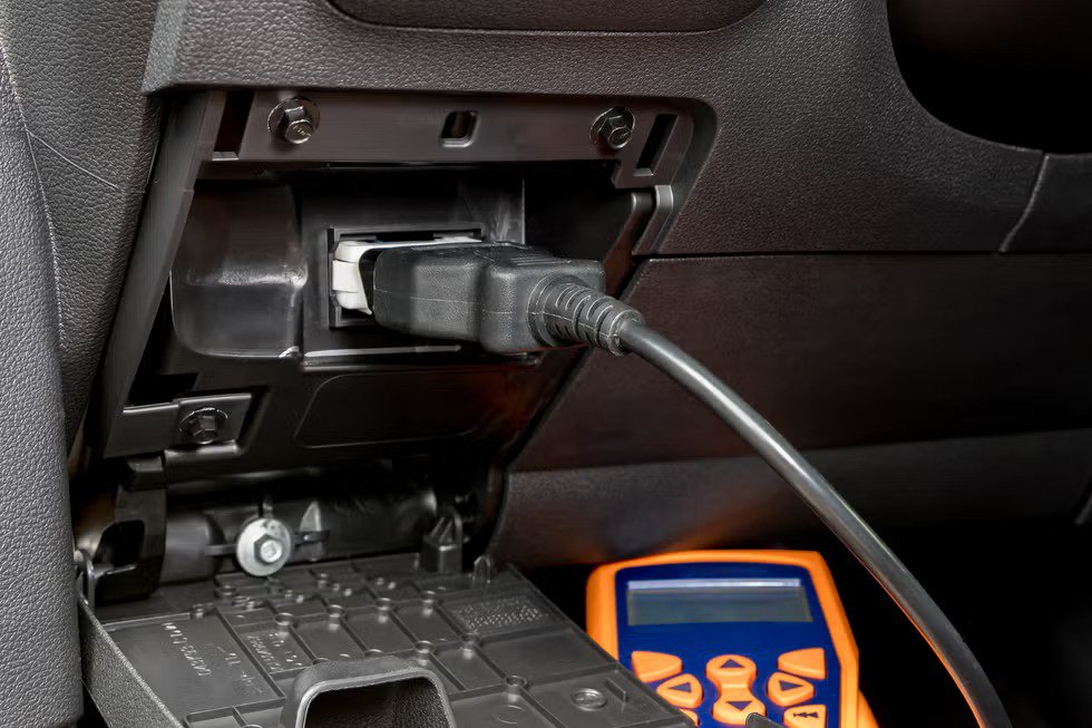 engine scan tool plugged into car computer connection. concept of automotive repair, maintenance, service and vehicle check engine light.
