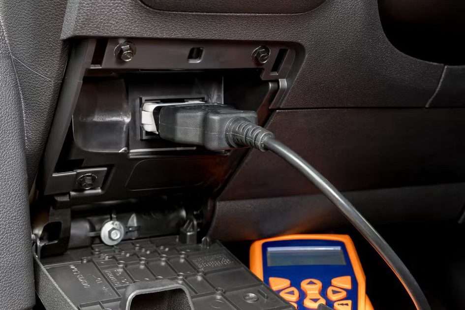 engine scan tool plugged into car computer connection. concept of automotive repair, maintenance, service and vehicle check engine light.