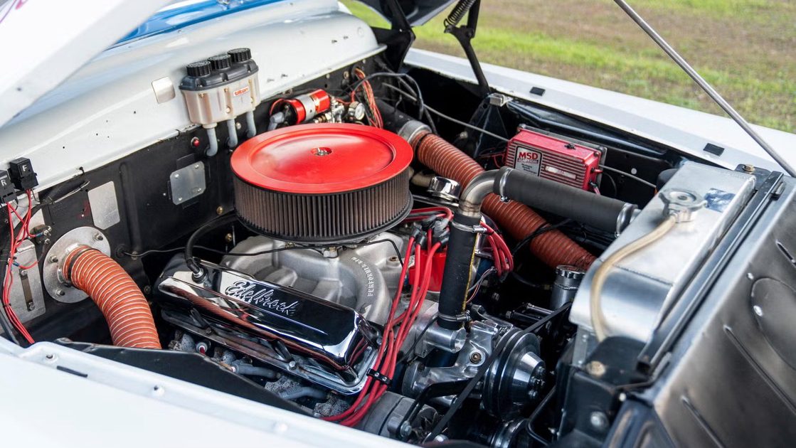 front view of engine bay with air filter housing, hoses, wiring, radiator.