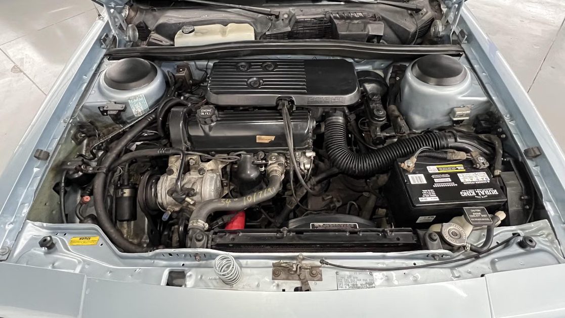 top view engine bay showing inline engine battery hoses reservoir and surrounding components.
