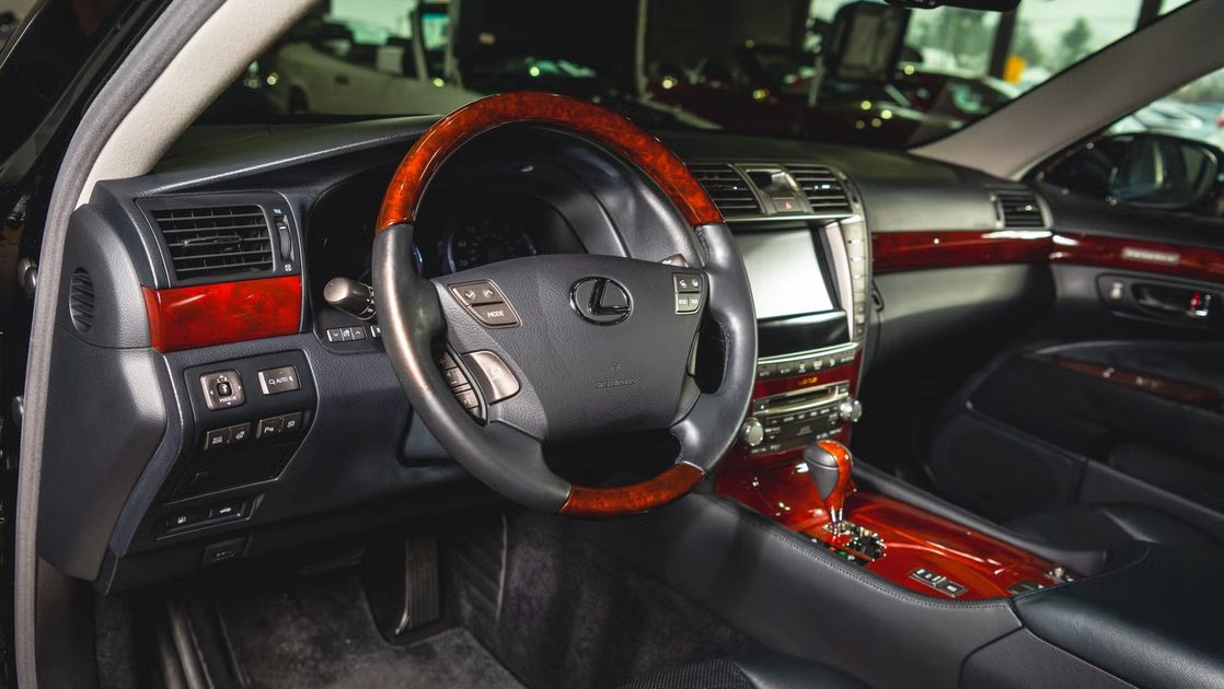 vehicle interior showing steering wheel wood trim center console touchscreen gear selector dashboard controls.