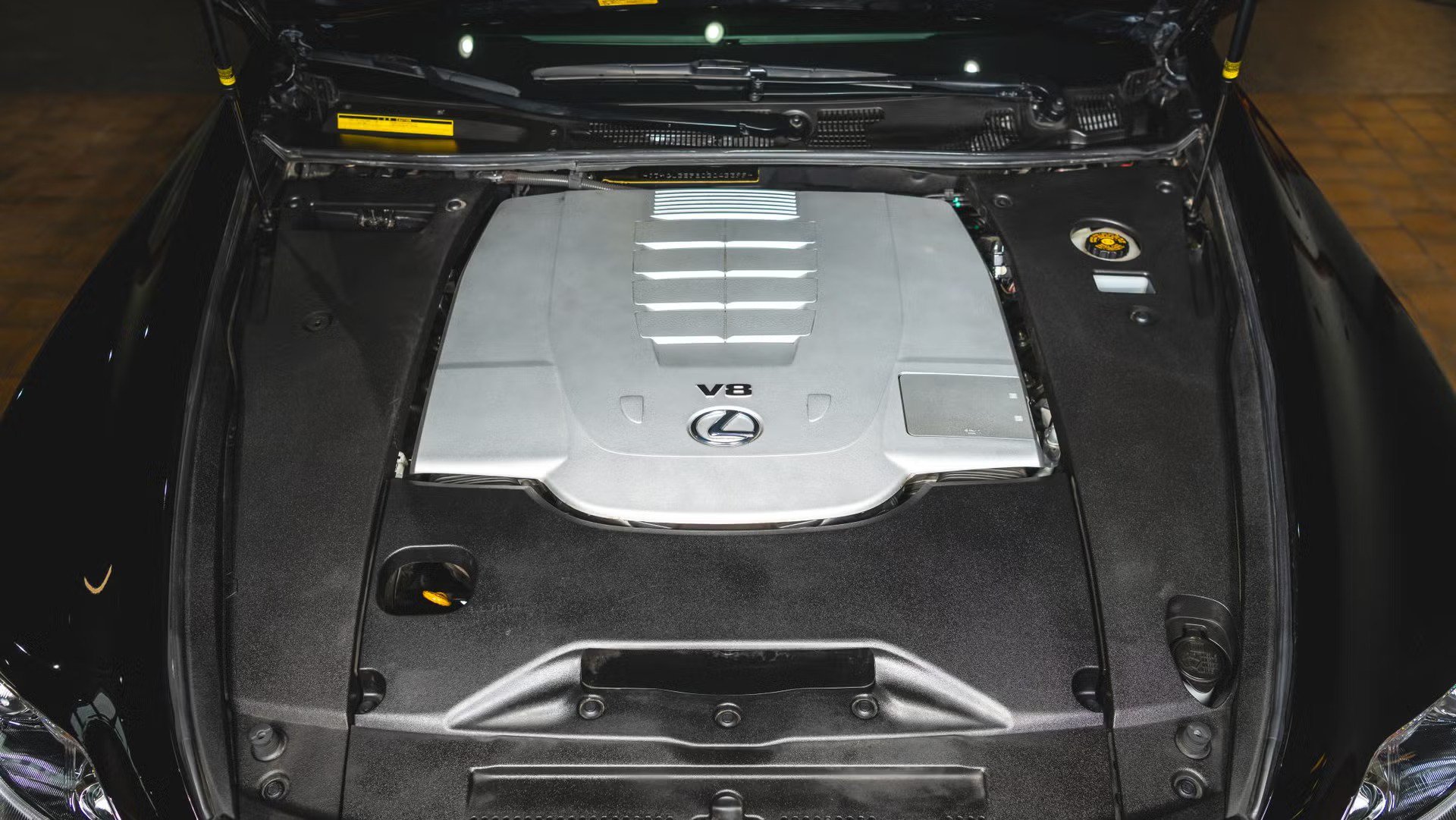top view engine bay showing v8 engine cover surrounding components and strut towers.